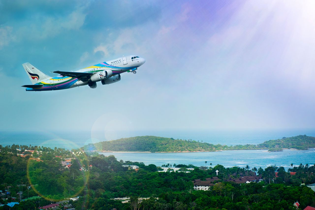 services-02 Airplane soaring over Koh Samui island, Thailand, showcasing a vibrant tropical landscape in daylight.
